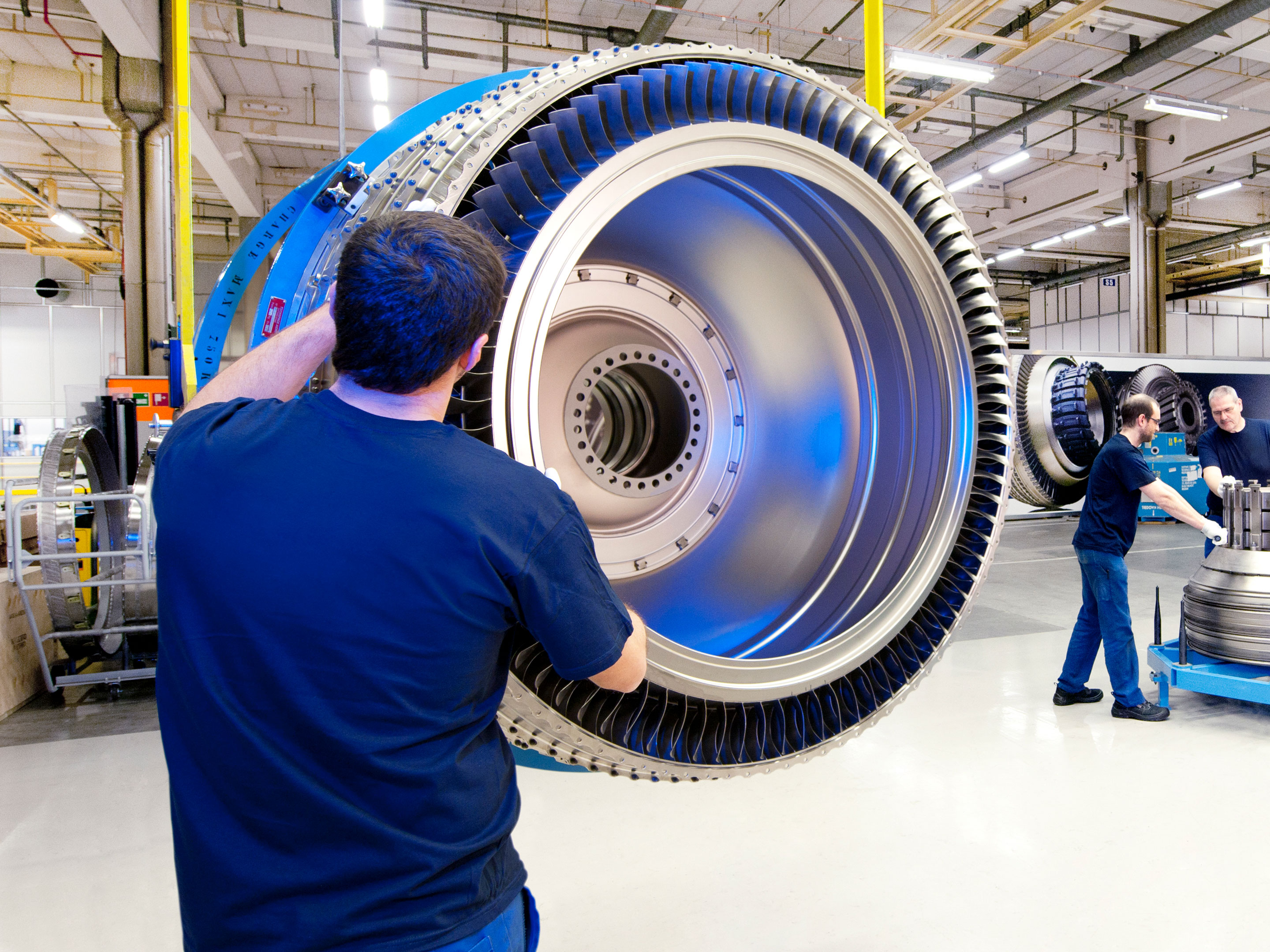 Man in blue shirt works on an aviation part.